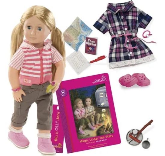 صورة دمية شانون من مجموعة "Our Generation"، تأتي في صندوقها الخاص مع ملابس إضافية وإكسسوارات للتخييم، وتتميز بشعر أشقر طويل وعينين زرقاوين، وترتدي ملابس مناسبة للمغامرات.